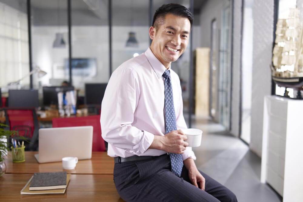 businessman holding cup of coffee in office
