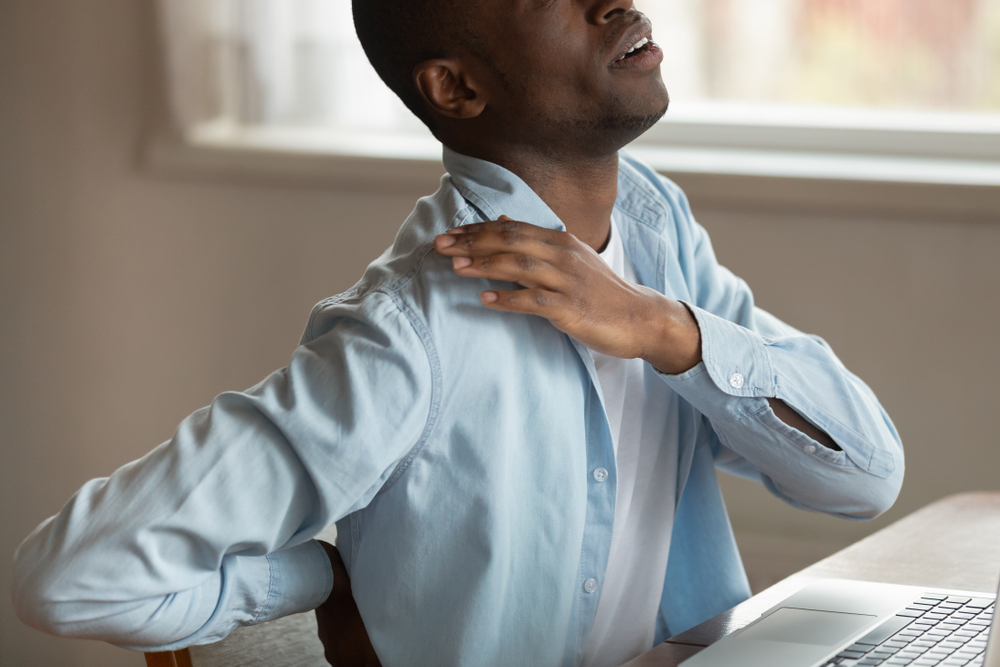 A man holding his back possibly dealing with Spine Trauma