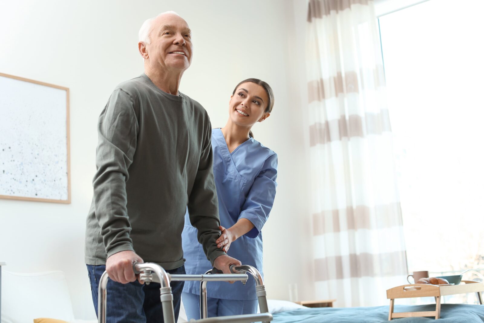 nurse helping man to walk using a walker