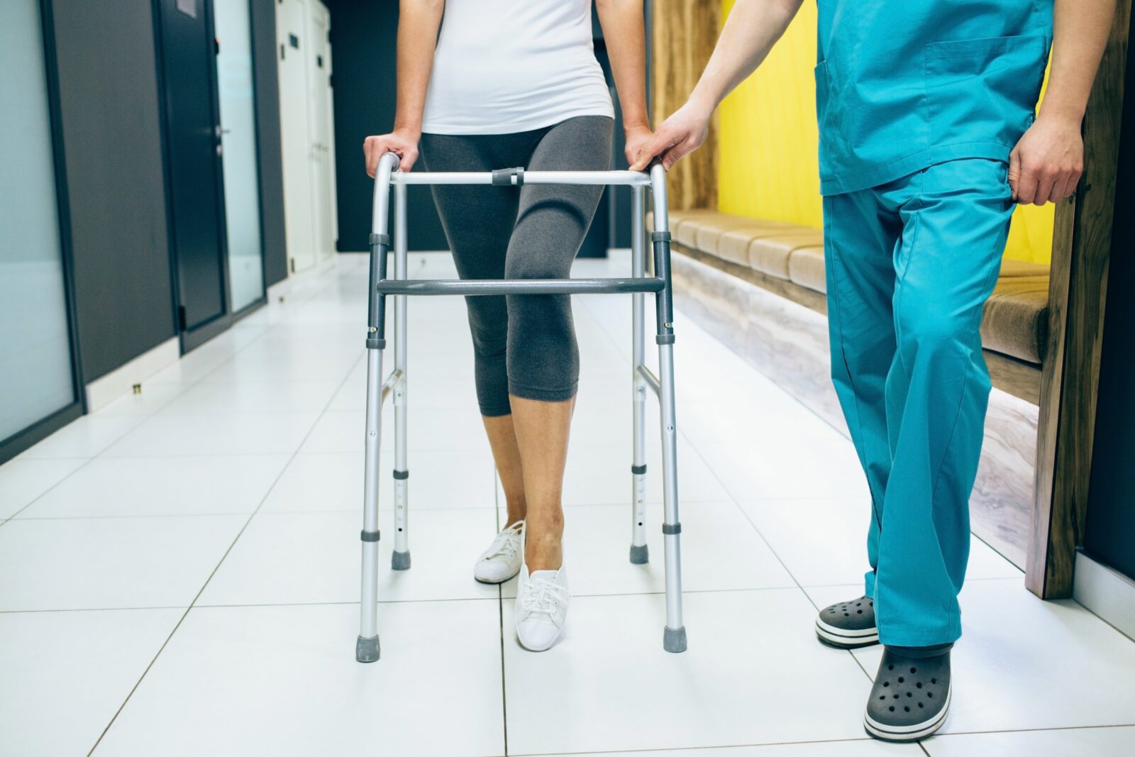 nurse assisting patient with walker