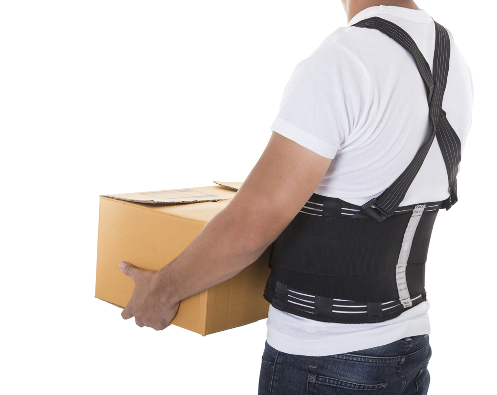 The man lifts a cardboard box wearing back support belt for protect body