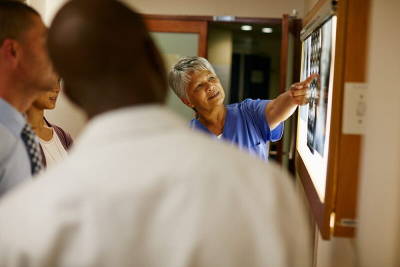 Healthcare, medical team and xray in clinic for discussion, consulting and planning