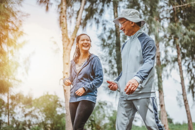 Health and lifestyle concept. Fitness, Exercising, jogging, running. Asian woman and Father walking exercise at outdoor park doing morning exercise.