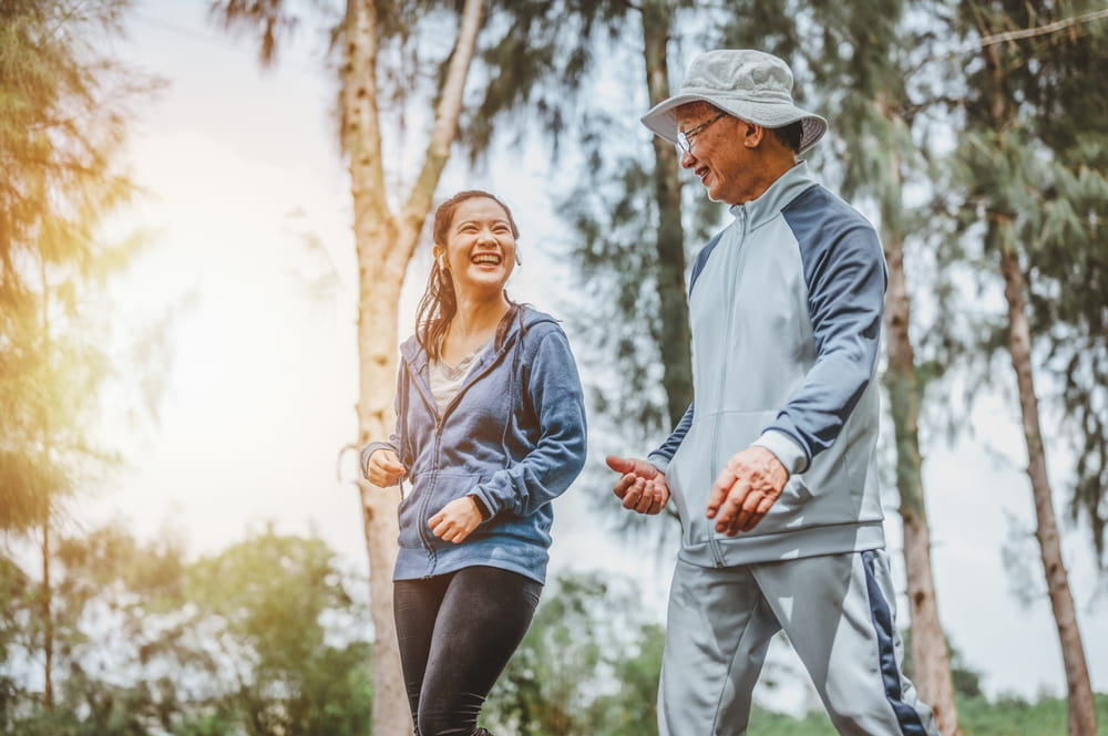 Health and lifestyle concept. Fitness, Exercising, jogging, running. Asian woman and Father walking exercise at outdoor park doing morning exercise.
