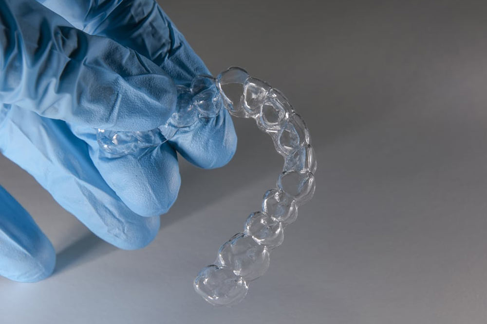 clear Invisalign bracket on isolated background