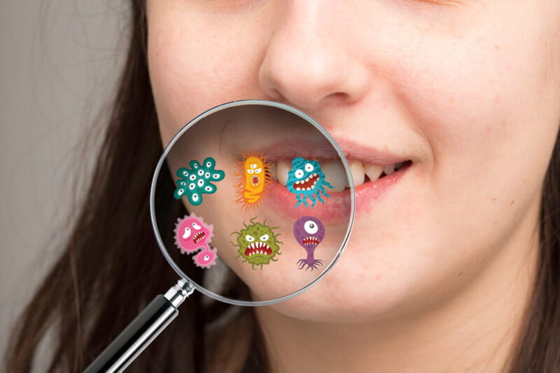 Magnifying glass showing possible microbes of the oral cavity re
