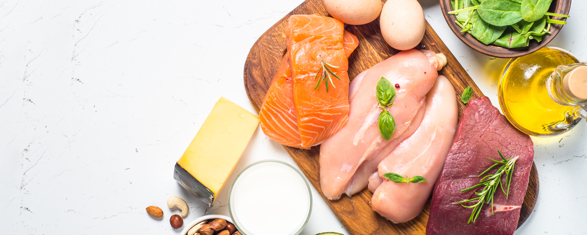 Ketogenic low carbs diet. Meat, fish, nuts, oil, cheese, milk and avocado on white background.