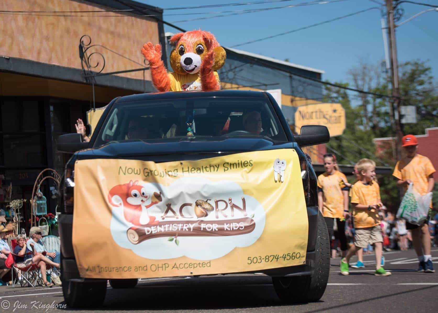 mascot in the back of a truck, promotional banner in the front