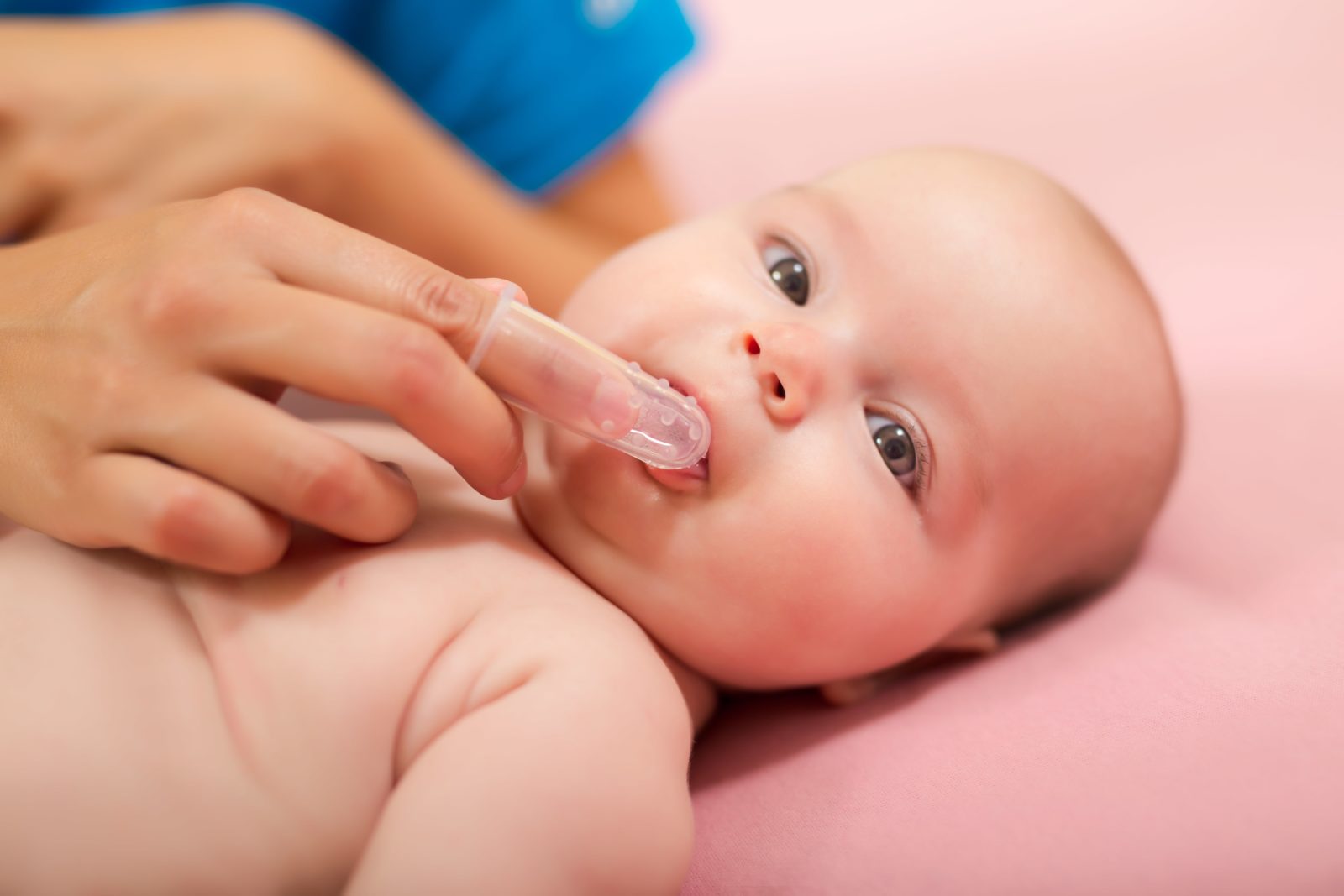 mother massaging baby's gums