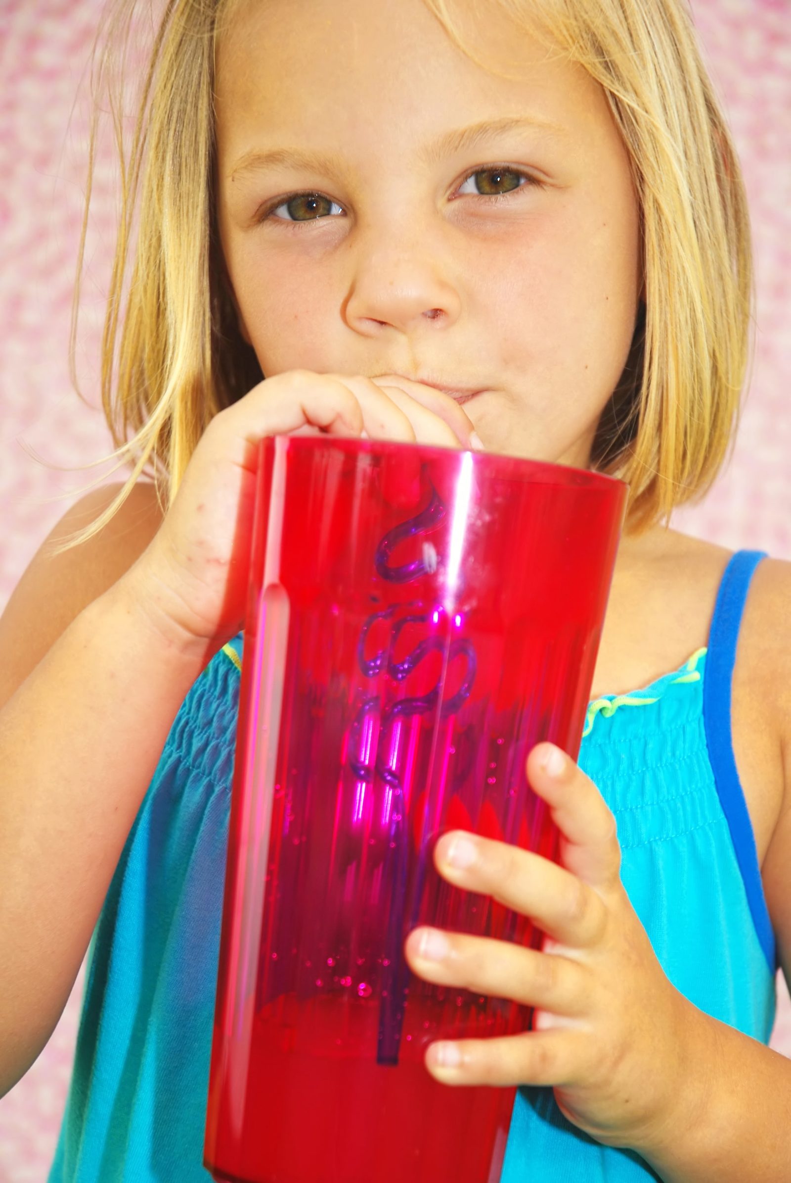 young girl drinking out of a crazy straw