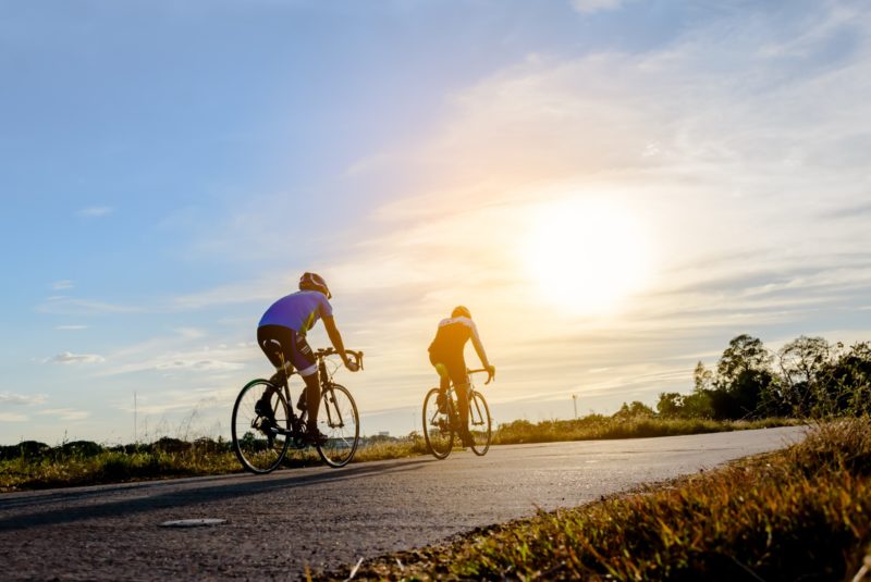 Two men ride on bike on the road