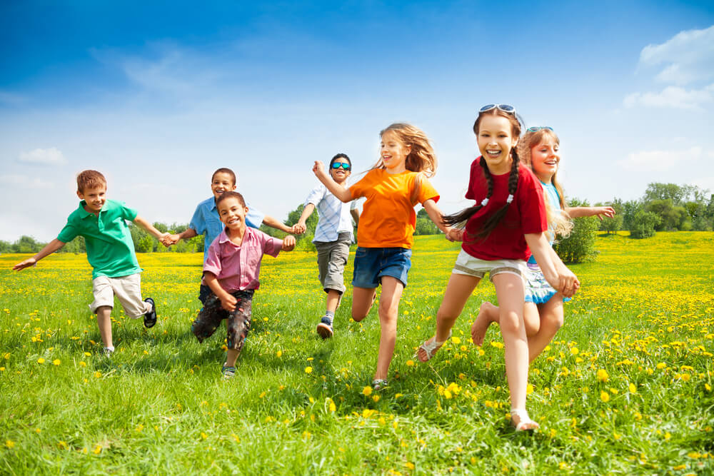 group of children smiling in grass
