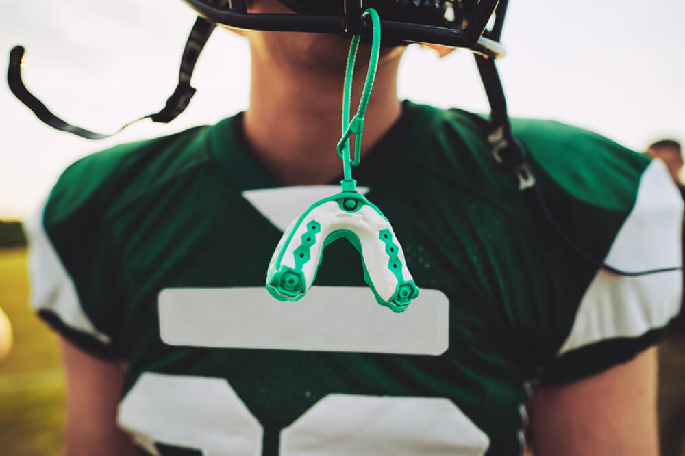teenager in football gear with hangout mouthguard