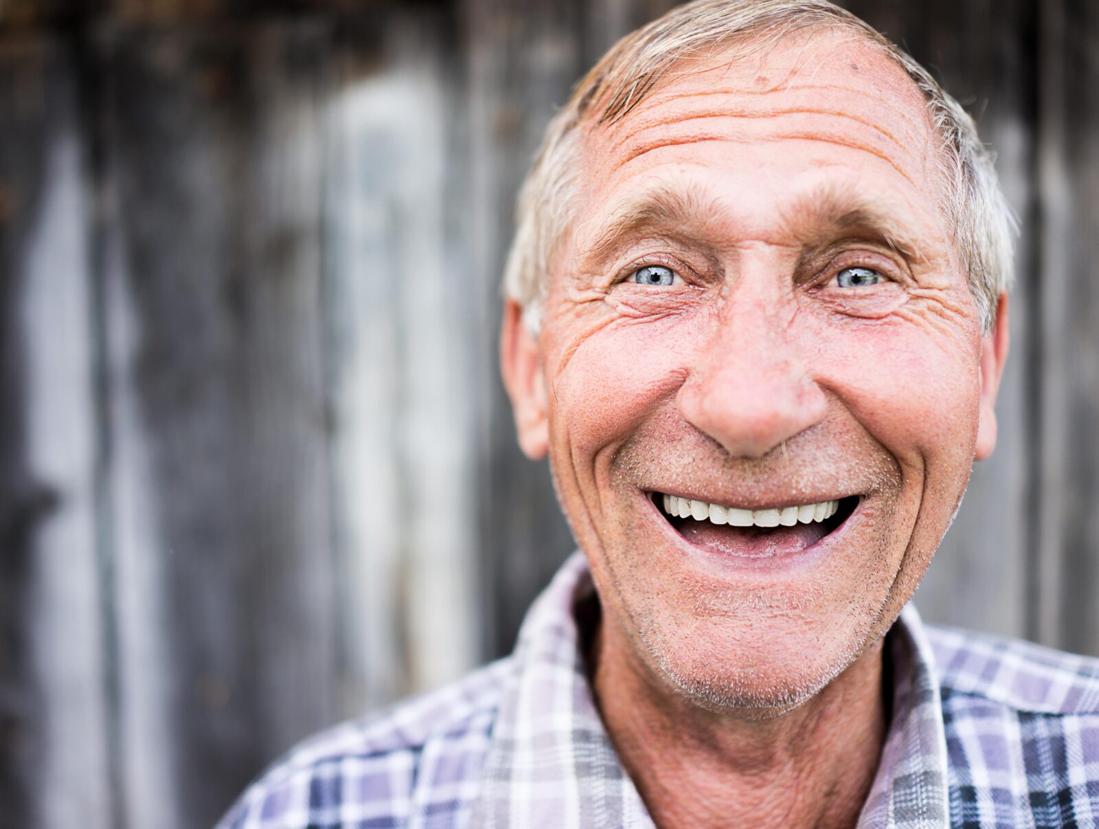 older man smiling with a full set of white teeth
