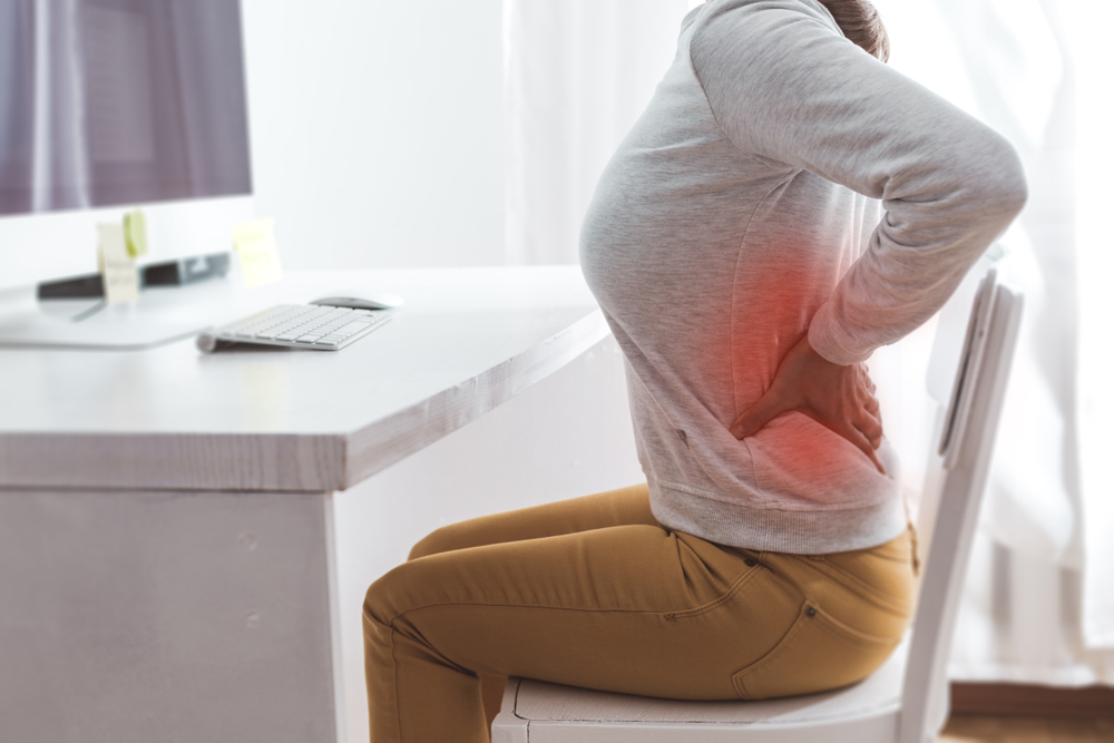 woman working on computer having lower back pain