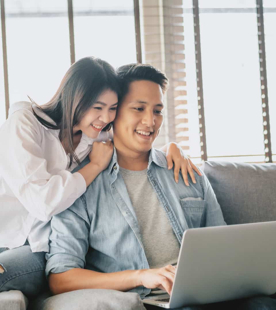 Beautiful Young couple smiling while watching laptop