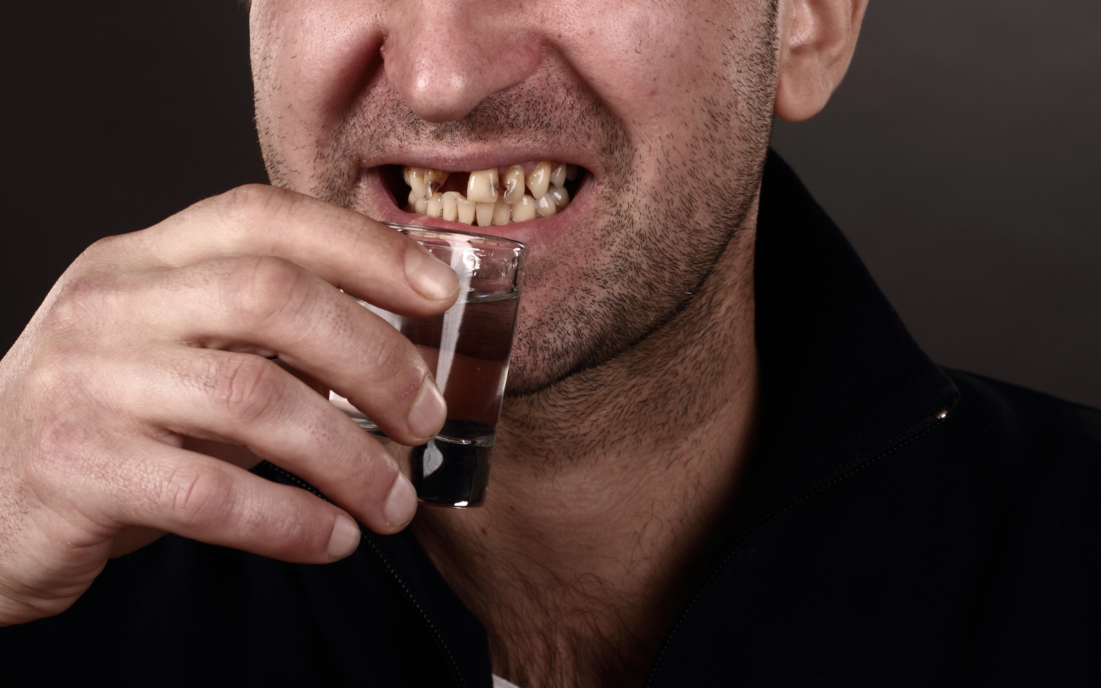 Man with Damaged teeth drinking alcohol
