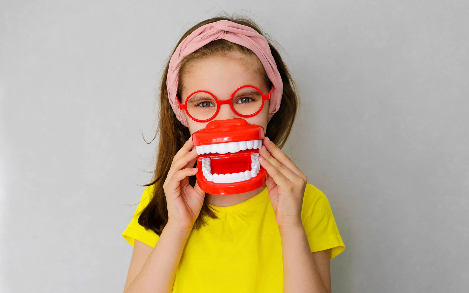 Smiling playful child with false teeth