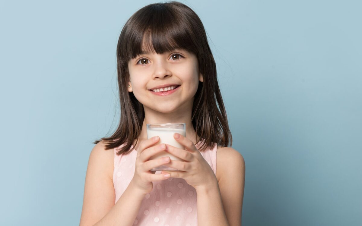 Small child drinking a glass of milk