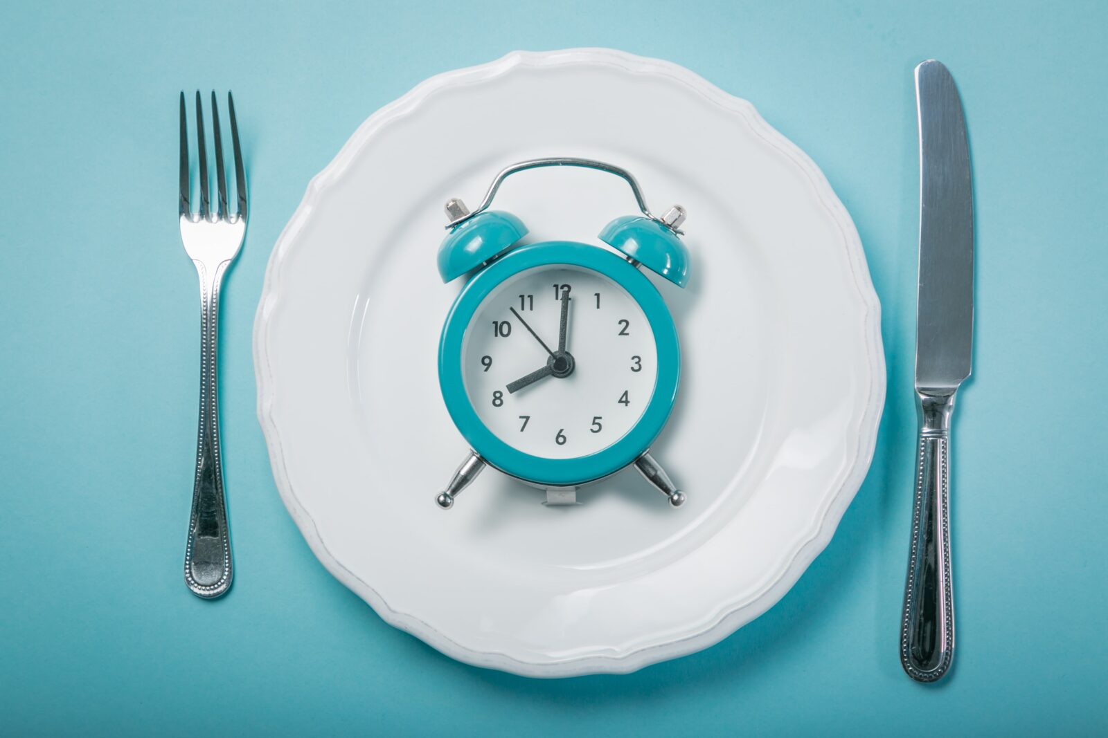 clock on a plate with silverware