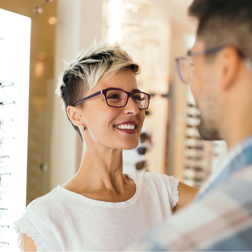 couple buying glasses from optical store
