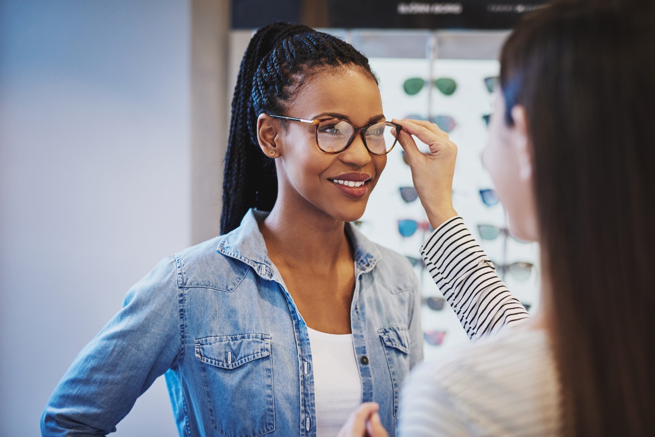 woman testing glasses at optical store