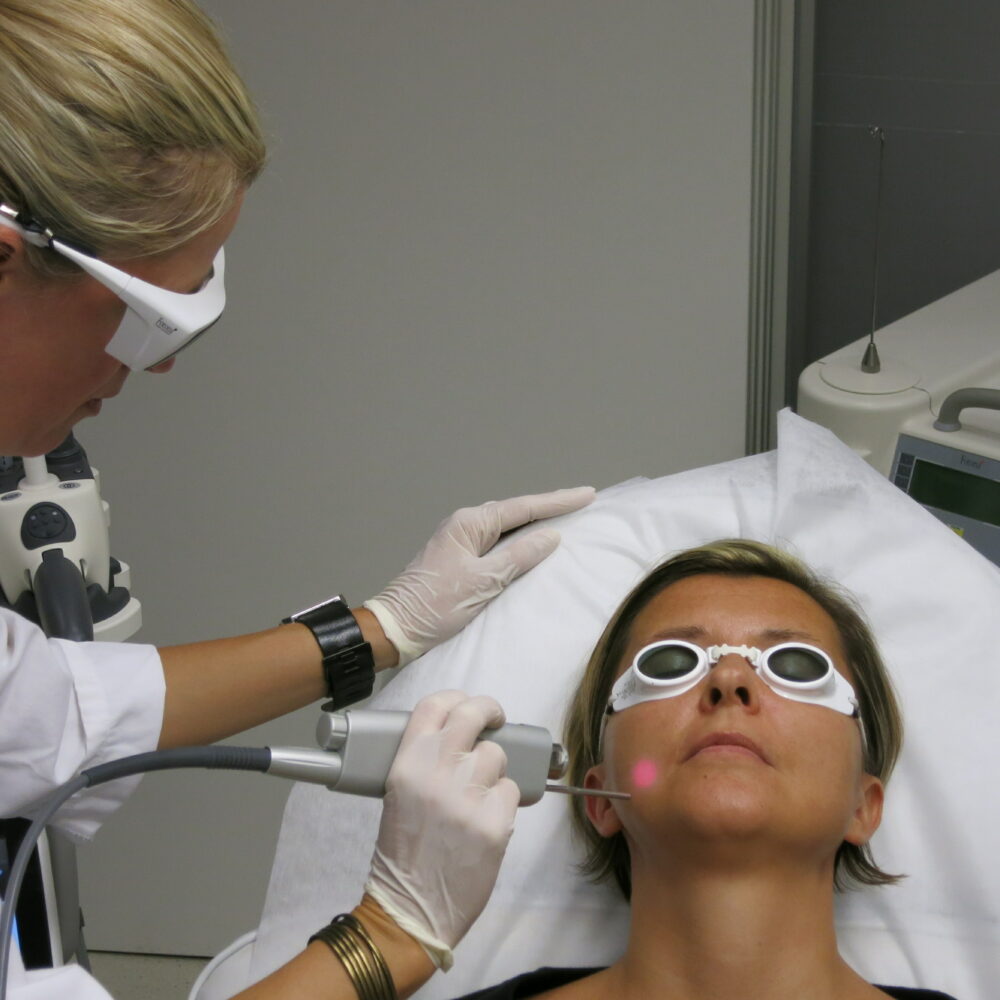 A cosmetic procedure with microcurrent injections in a beauty salon is performed for an aged woman