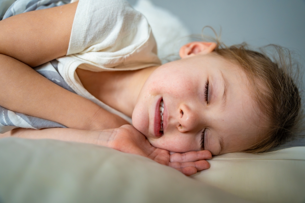 Cute little girl sleeping and grinding teeth in dreams