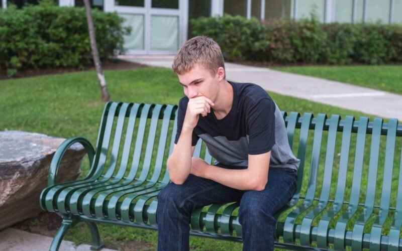 College Student Struggling Siting on a Bench