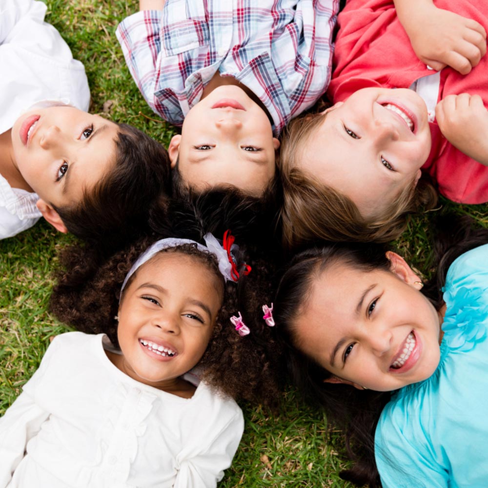 Happy group of kids lying on the floor in a circle