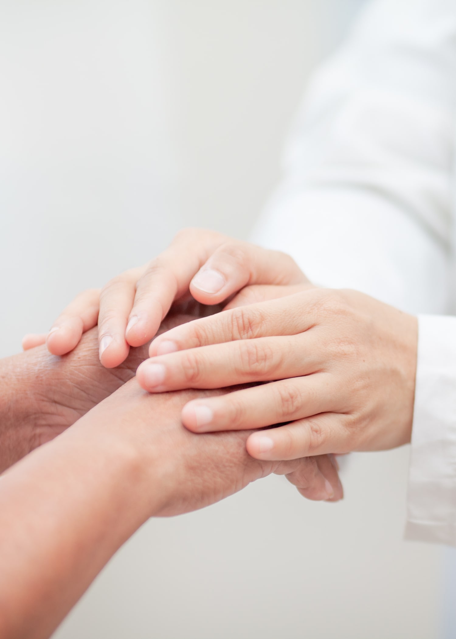 Hands of doctor holding the hand of a patient for the consolation