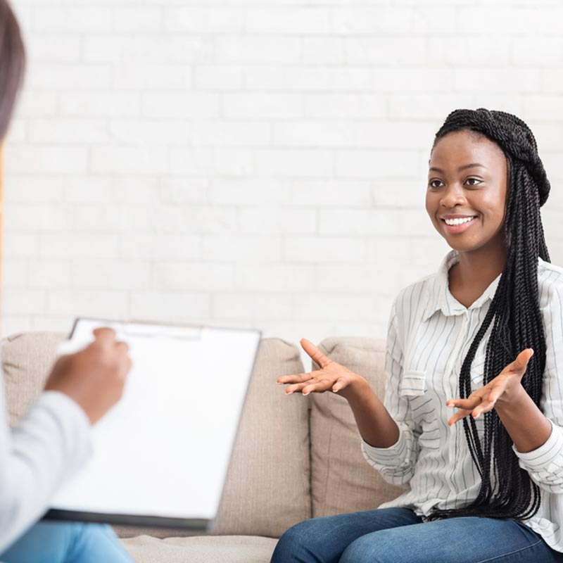 Happy female patient talking to psychologist