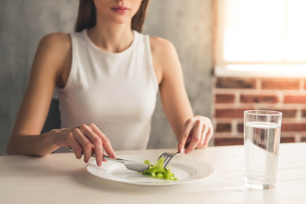 Eating disorder. image of girl eating lettuce