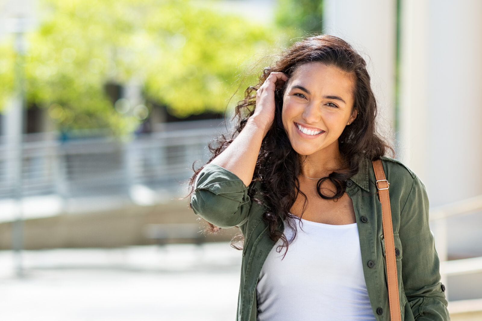 Happy young beautiful woman walking on the street