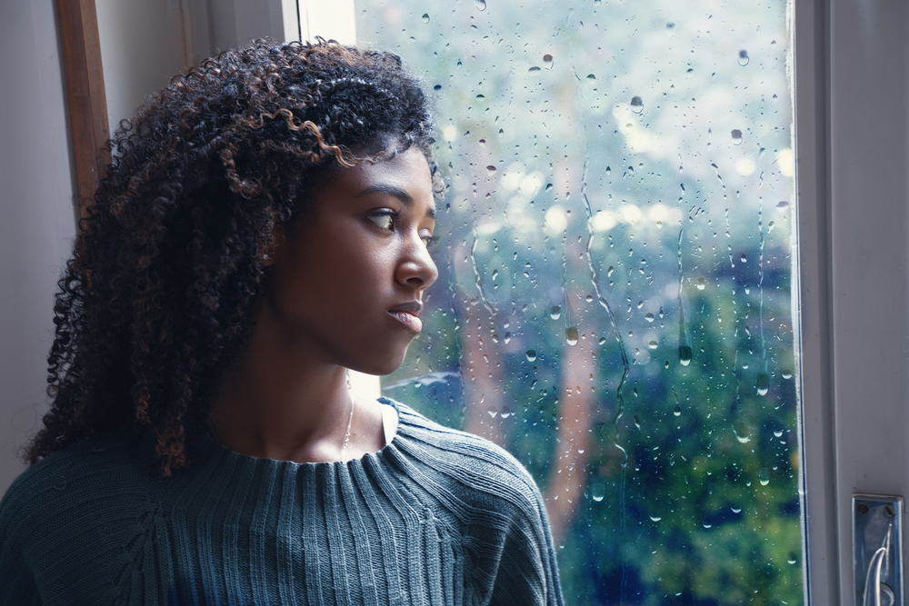 woman at window showing signs of bipolar disorder