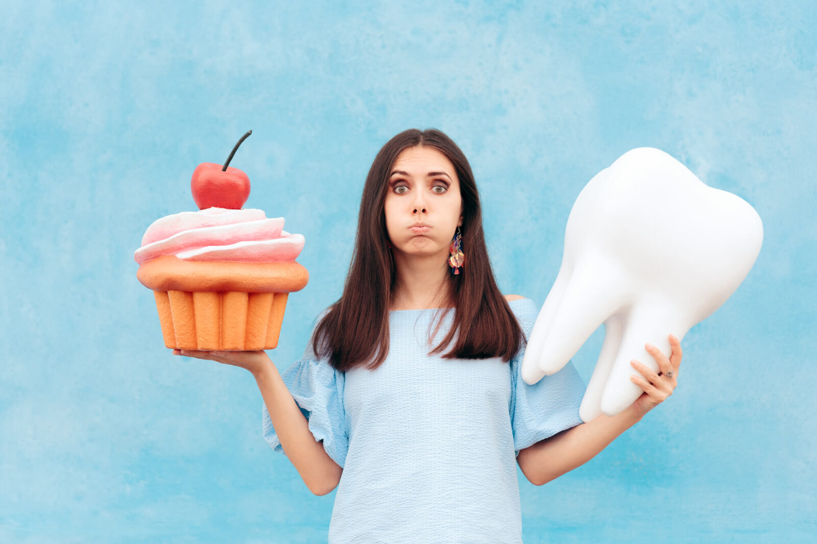 woman carries stuffed toy cupcake and veneers in Coral Springs