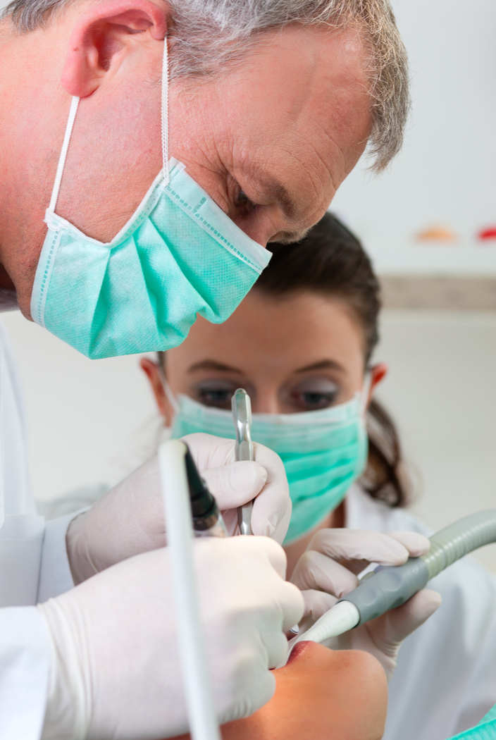 patient with dentist and assistant in a dental treatment