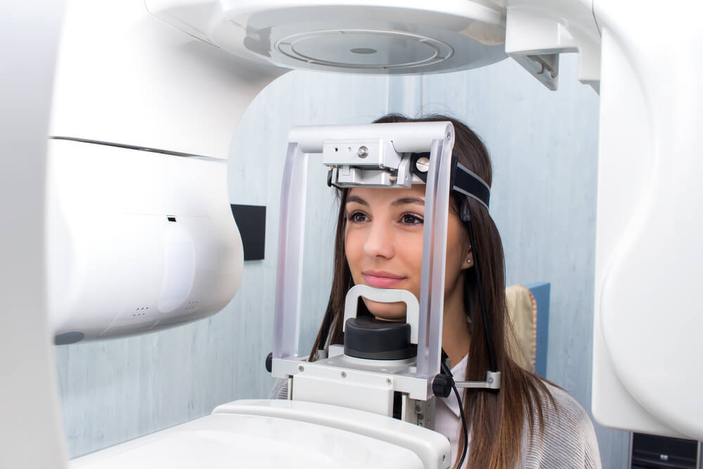 girl taking dental tac with cephalometric panorama x-ray