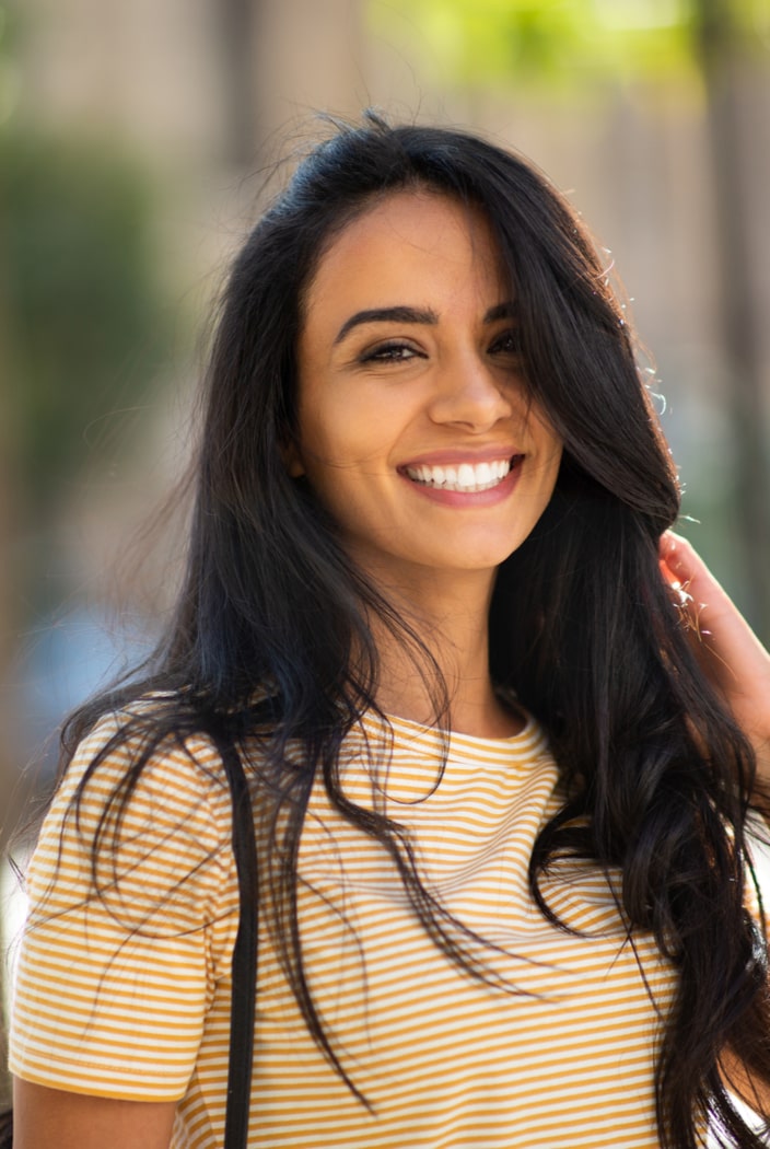 happy young woman smiling with hand in hair