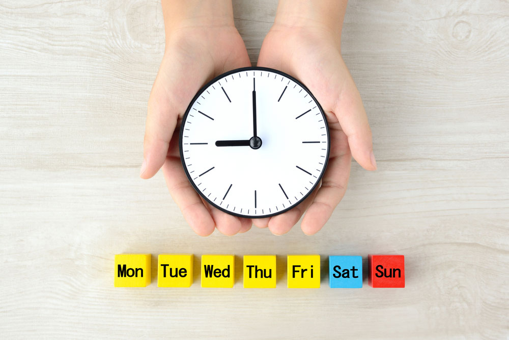 Child happily holding a clock to maintain routine and reduce anxiety