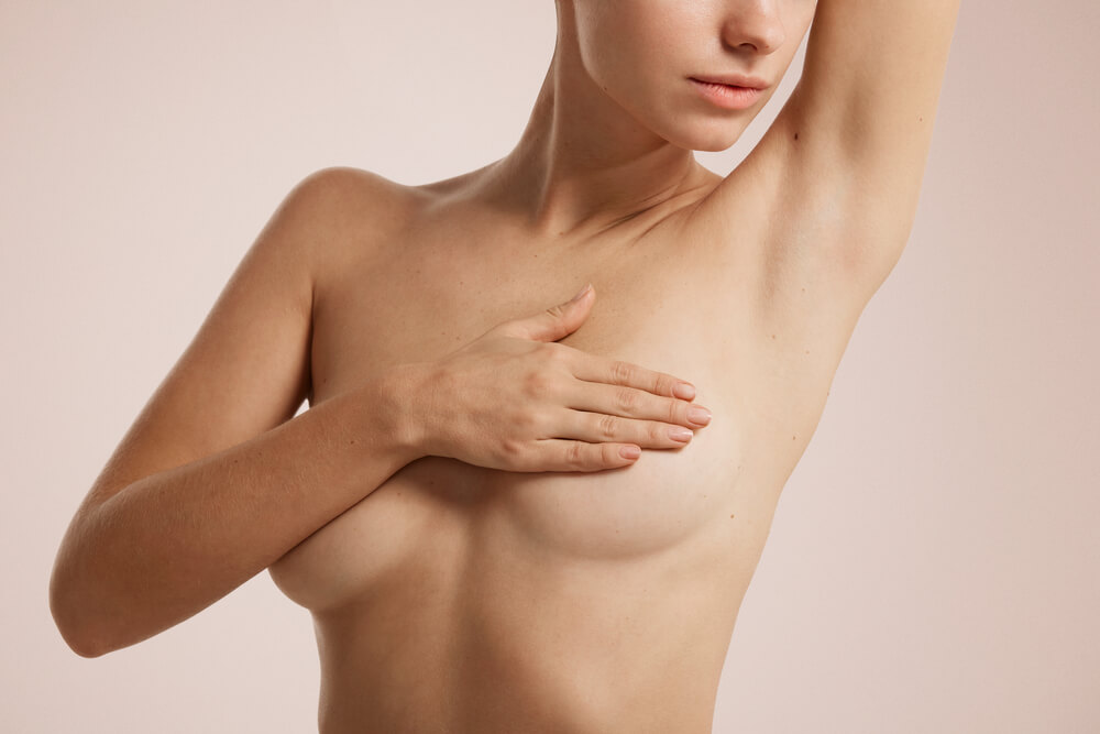 young woman with breast pain touching chest