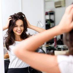 Happy woman smiling looking at mirror
