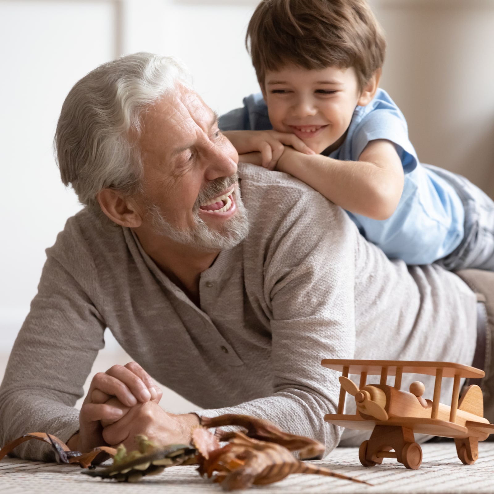 Happy little boy lying on grandfather