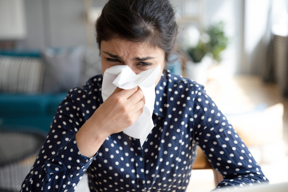 Woman blowing her nose, dealing with Nasal Congestion