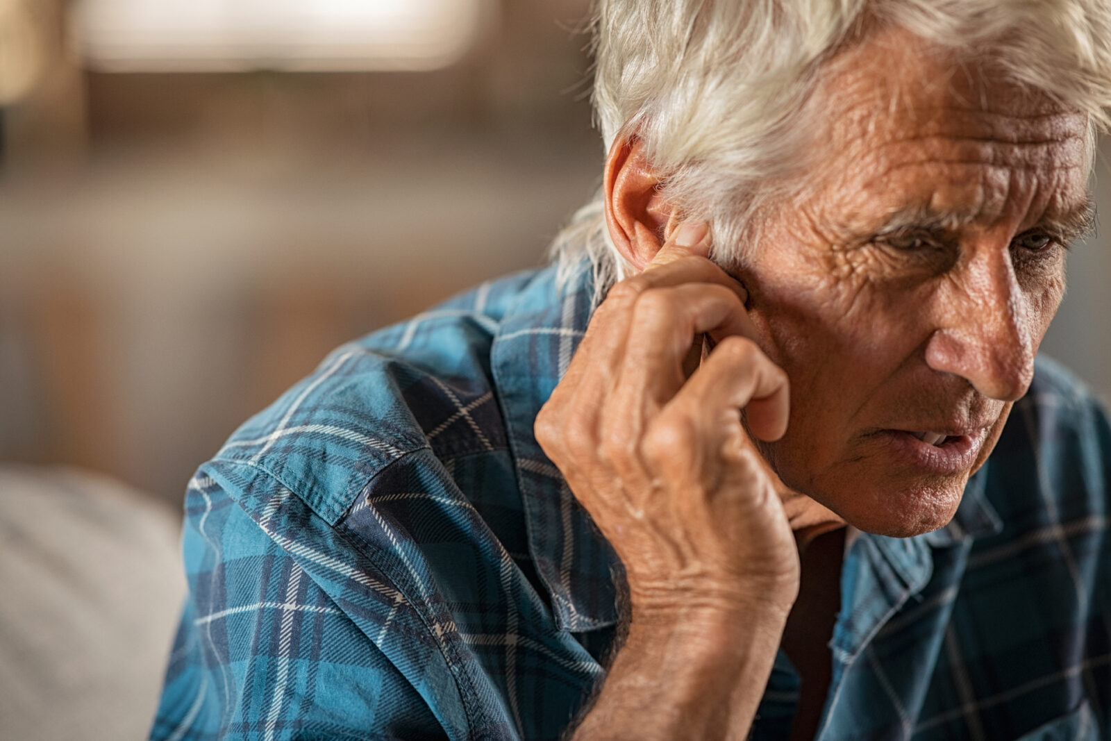 Man grabs his ear suffering from possible Ear Congestion and Pain