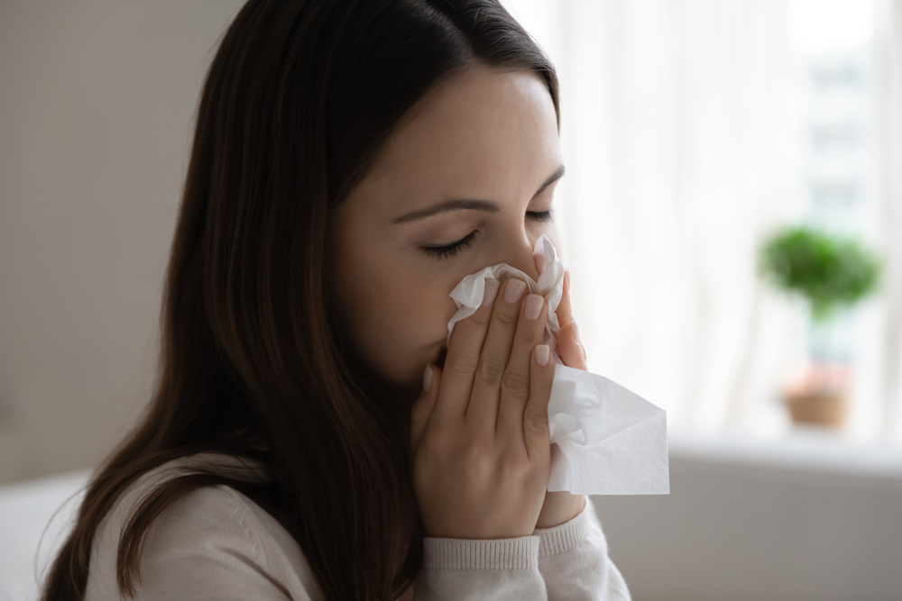 Woman blowing her nose into a tissue