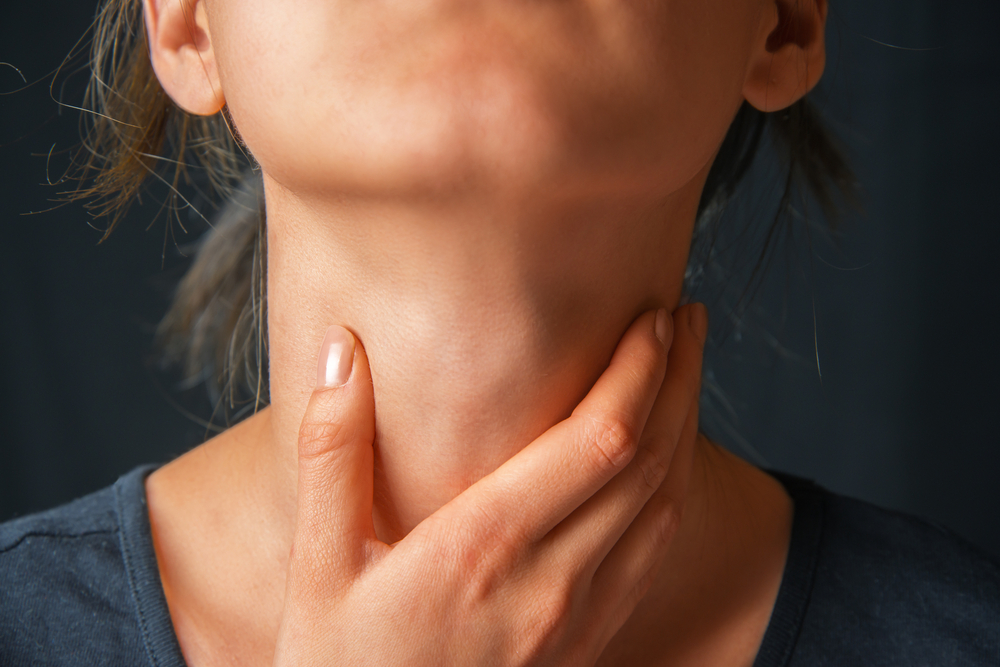 Woman holding her throat suffering from Hoarseness