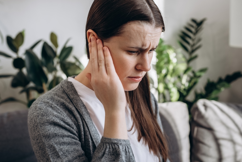 Woman holding her ear suffering from Sudden Hearing Loss