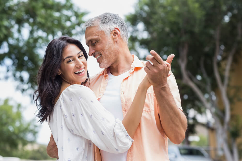 beautiful woman with man dancing in city