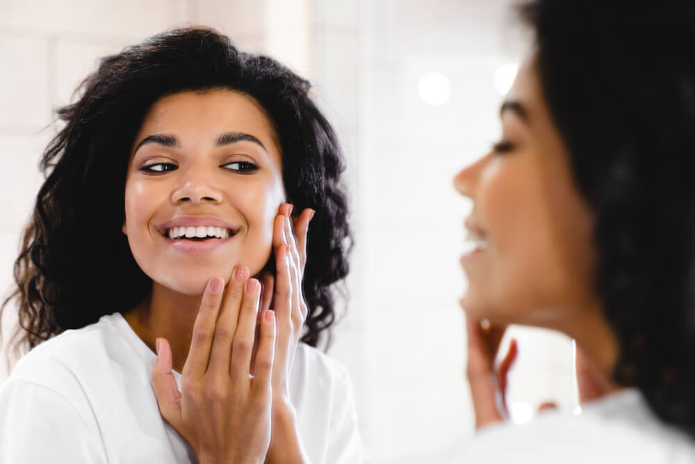 girl smiling in front of mirror after treatment